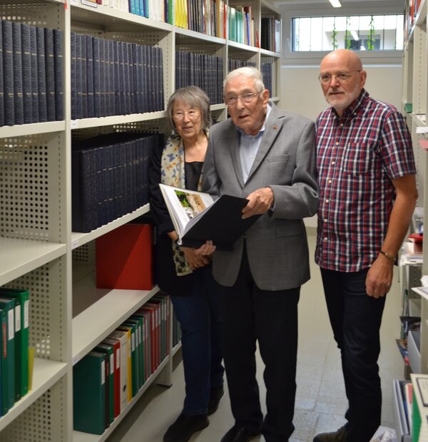 Herr Waldhoff h&auml;lt eines seiner selbst erstellten B&auml;nde &uuml;ber die Stadtgeschichte in den H&auml;nden. Neben im stehen Frau Sternberg-El Hotabi und Herr Br&auml;kling.